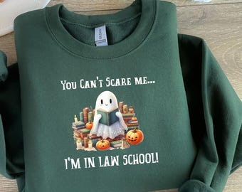 Peut inclure: Sweat-shirt vert avec un fantôme blanc lisant un livre entouré de livres et de citrouilles. Le texte sur le sweat-shirt est "You can't scare me... I'm in law school!"