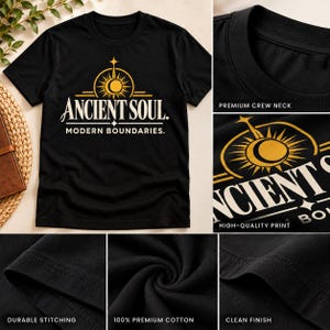 Op de afbeelding: Een zwart t-shirt met korte mouwen en een goud-witte afbeelding van een zon- en maansymbool boven de tekst ANCIENT SOUL. MODERN BOUNDARIES. Het shirt heeft een ronde hals, duurzame stiksels en een nette afwerking van 100% premium katoen.