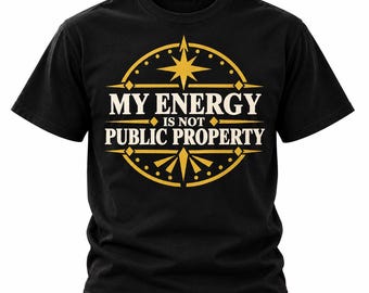 Può includere: Una t-shirt nera a maniche corte con una grafica circolare dorata e una stella nella parte superiore. Il testo al centro recita MY ENERGY IS NOT PUBLIC PROPERTY in lettere maiuscole bianche, incorniciato da linee geometriche e rombi.