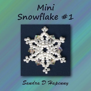 Puede incluir: Un copo de nieve blanco de cuentas con detalles de cristal transparente. El copo de nieve está sobre un fondo azul oscuro. El texto "Mini Snowflake #1" y "Sandra D. Hapenny" están debajo del copo de nieve.