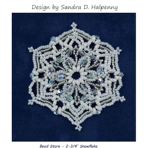 Puede incluir: Un primer plano de un adorno de copo de nieve blanco hecho con cuentas de semillas y cristales. El copo de nieve tiene un diámetro de 7 cm. La leyenda dice "Snowflake #163 Ornament Pattern Design by Sandra D. Halpenny Bead Store - 2-3/4" Snowflake A = Miyuki 11° SEED bead, 550* beads C = 4mm Fire-polished Crystals, 24 beads T = Twin Beads, 60 beads *I randomly used silver lined seed beads"
