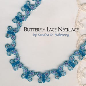 Puede incluir: Un collar de cuentas azul y morado con un diseño de mariposa. El collar se llama "Butterfly Lace Necklace" de Sandra D. Halpenny.