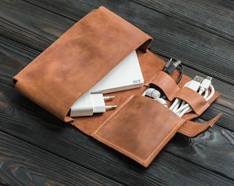 Könnte beinhalten: Eine braune Leder-Reisehülle mit mehreren Fächern zum Verstauen von Elektronik und Zubehör. Die Hülle ist geöffnet und zeigt eine weiße Powerbank mit dem Text "ZMI" darauf, sowie mehrere weiße Ladekabel und ein Paar weiße Ohrhörer.