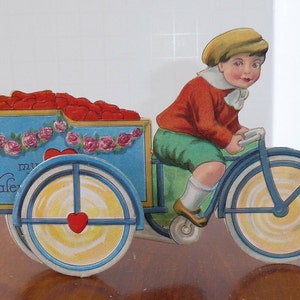 Ancien garçon debout à vélo découpé avec des matrices en relief en relief, signé