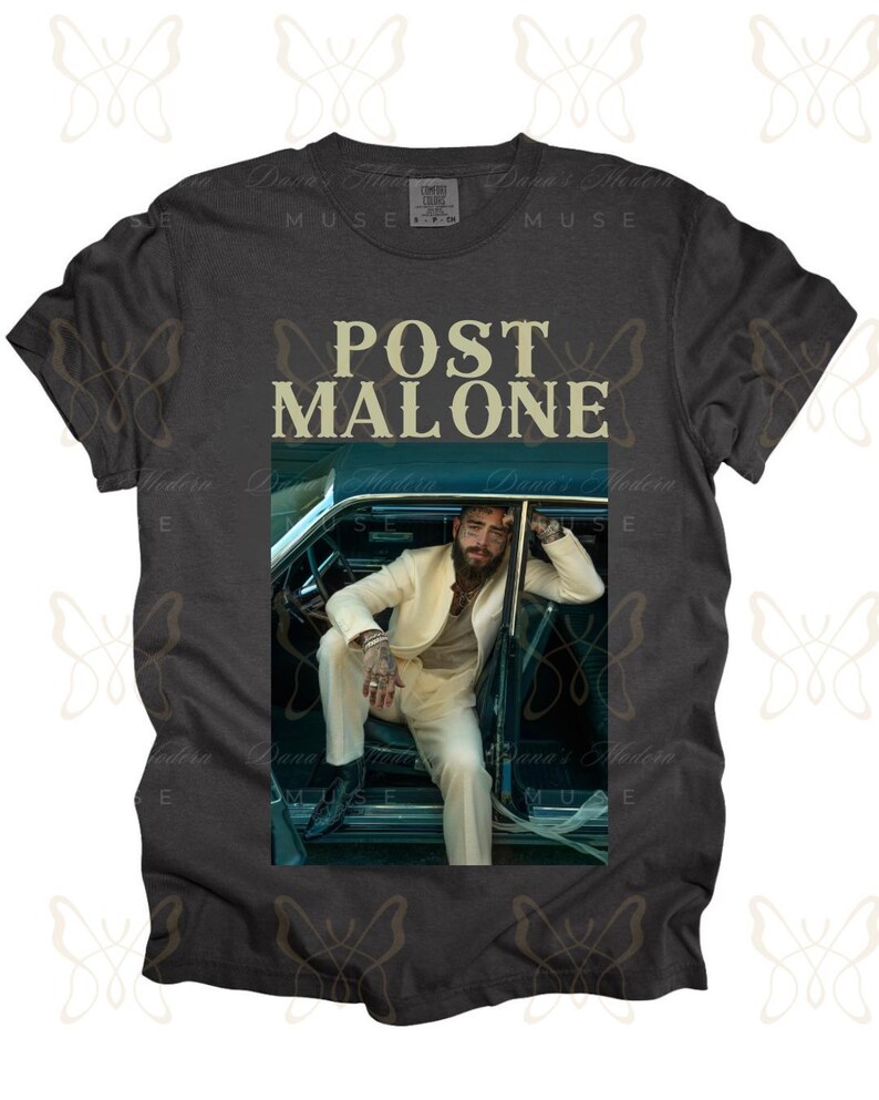May include: A dark grey t-shirt with a white graphic of Post Malone sitting in a car. The text "Post Malone" is printed in yellow on the shirt.