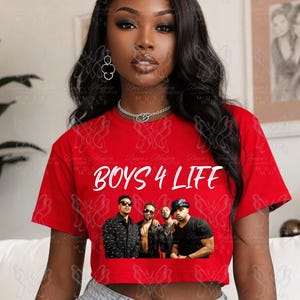 May include: A red crop top with the text "BOYS 4 LIFE" in white. Below the text is a photo of four men. The top is short-sleeved and has a crew neck.