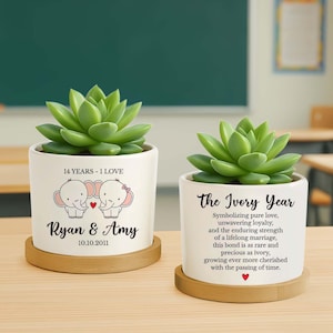 May include: Two white ceramic planters with green succulents. One planter has a design of two elephants, a heart, and the text "14 YEARS - I LOVE", "Ryan & Amy", and "10.10.2011". The other planter has the text "The Ivory Year" and a description.