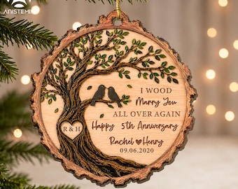 Pode incluir: Um ornamento redondo de madeira com borda de casca natural, gravado com uma árvore de folhas verdes, dois pássaros num galho e um coração com R&H. O texto diz: I WOOD Marry You ALL OVER AGAIN Happy 5th Anniversary Rachel & Henry 09.06.2020.