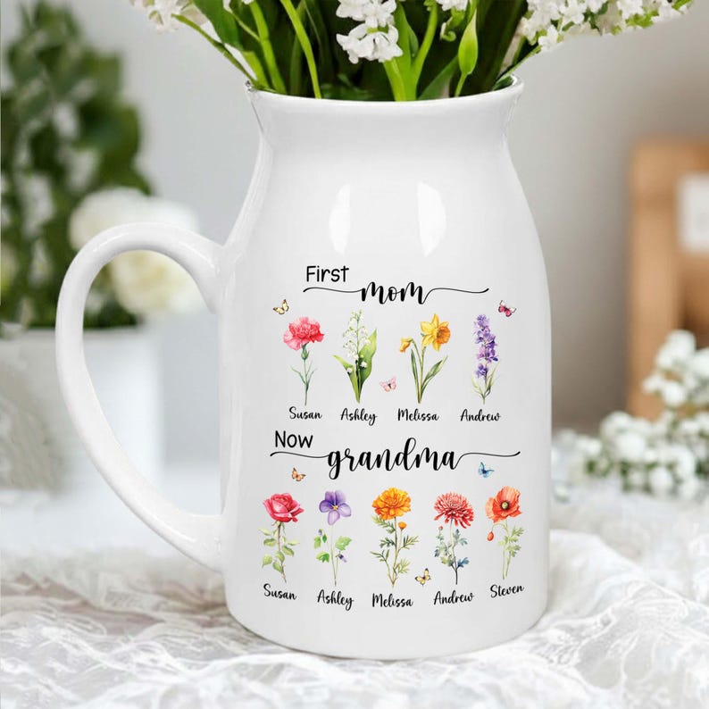 Pu&ograve; includere: Brocca in ceramica bianca con manico, piena di fiori bianchi. La brocca &egrave; decorata con illustrazioni floreali e la scritta "First mom, now grandma" con nomi sotto i fiori.