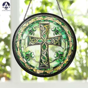 May include: A round stained glass window hanging from a chain. The window features a green Celtic cross with a knot design and shamrocks around the cross. The background is a light green with yellow accents.