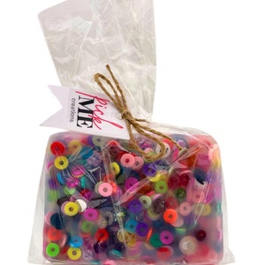 May include: A clear plastic bag filled with colorful round beads. The bag is tied with twine and has a tag that says "pick me creations".