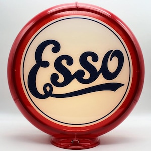 May include: A vintage Esso gas station sign. The sign is round with a red border and a white center. The word "Esso" is written in navy blue script. The sign has a red base and is lit from within.