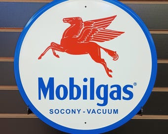 Könnte beinhalten: Ein rundes, blaues und weißes Metallschild mit einem roten geflügelten Pferdesymbol und dem Text "Mobilgas SOCONY-VACUUM".