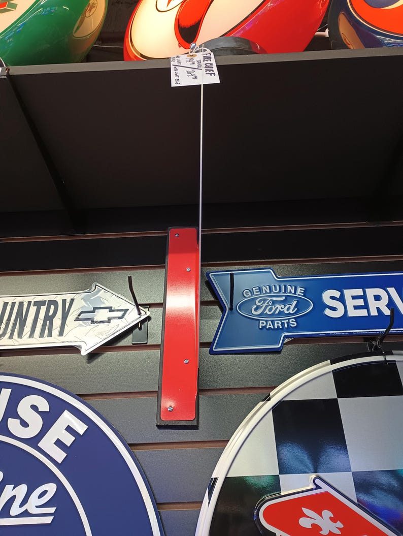 K&ouml;nnte beinhalten: Eine Sammlung von Vintage-Metallschilden mit verschiedenen Designs, darunter ein roter und wei&szlig;er Pfeil mit dem Text "Original Ford Teile", ein blauer und wei&szlig;er Pfeil mit dem Text "Service", ein silberner Pfeil mit dem Text "Country" und ein blauer und wei&szlig;er Kreis mit dem Text "House of Wine".