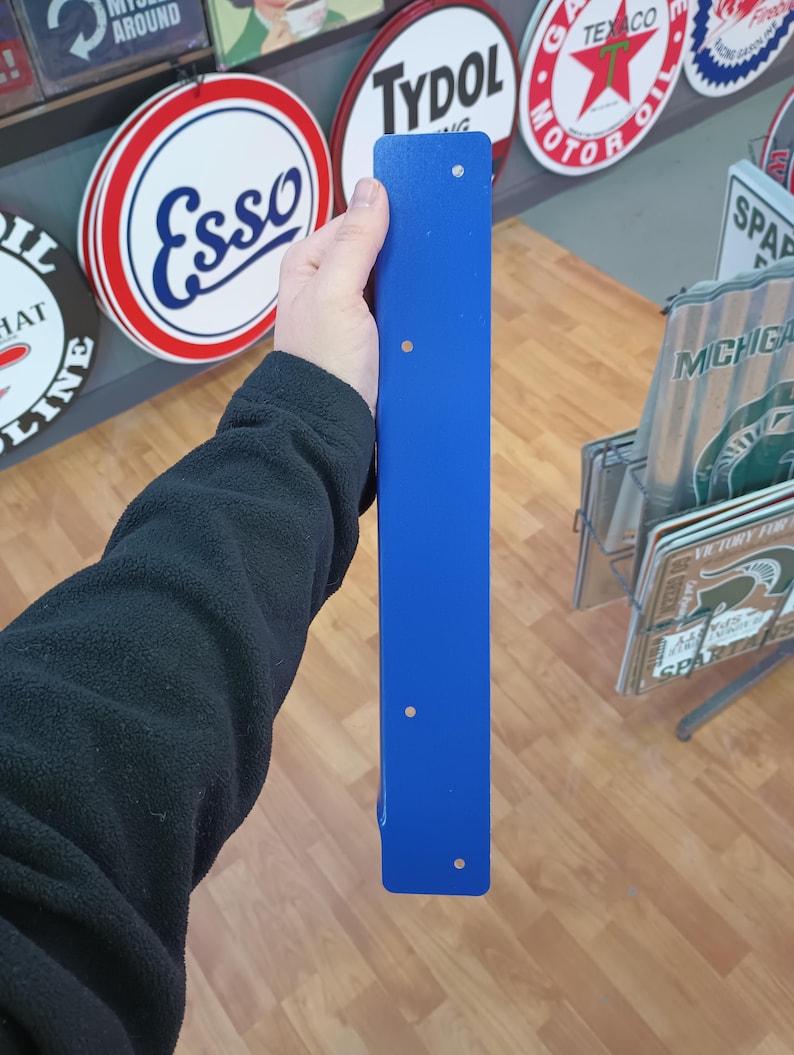 K&ouml;nnte beinhalten: Ein langes, schmales, blaues Metallwinkelst&uuml;ck mit f&uuml;nf gebohrten L&ouml;chern. Das Winkelst&uuml;ck wird in der Hand einer Person gehalten.