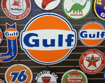 Könnte beinhalten: Eine Sammlung von Vintage-Tankstellenschildern, darunter Gulf, Texaco, Mobilgas, Sinclair und Rebel Gas. Die Schilder sind alle rund und weisen verschiedene Farben und Designs auf.