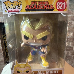 May include: A Pop! Animation vinyl figure of All Might from My Hero Academia, number 821. The figure is in a clear plastic display case. All Might is depicted in a dynamic pose, wearing a blue, red, and yellow costume.
