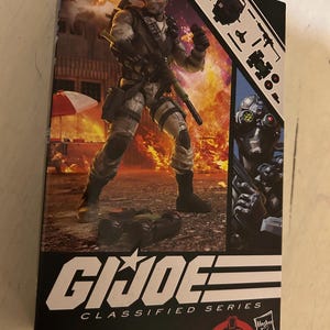 May include: A G.I. Joe Classified Series Cobra Firefly action figure box featuring a character in camouflage gear holding a rifle against an explosion background. The packaging displays included accessories, the G.I. Joe logo, and the Cobra emblem.