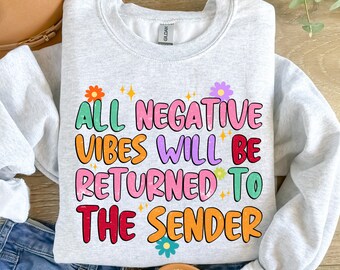 May include: Gray sweatshirt with the text "All negative vibes will be returned to the sender" in colorful letters with flowers and sparkles.