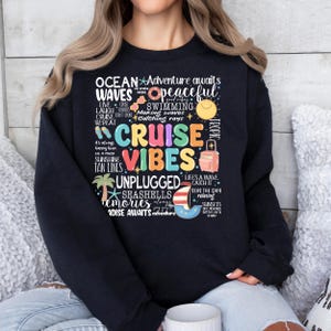 Peut inclure: Sweat-shirt noir avec du texte color&eacute; qui dit "Ocean Waves", "Cruise Vibes", "Adventure Awaits", "Unplugged", "Seashells", "Memories", et "Paradise Awaits".