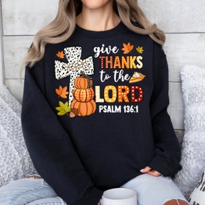May include: Black sweatshirt with a white and black cross, pumpkins, fall leaves, and the text "give thanks to the LORD PSALM 136:1".