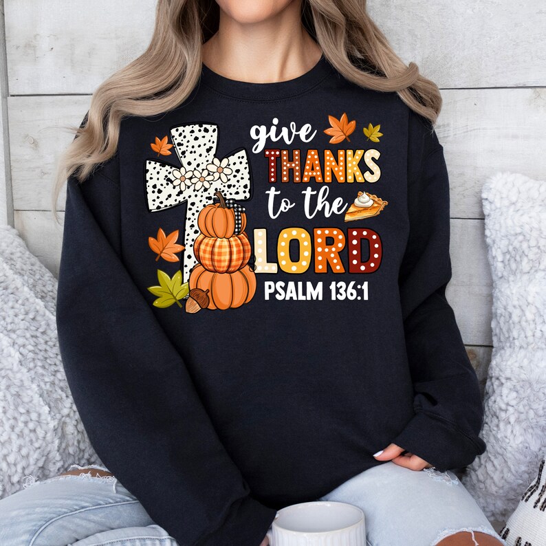 May include: Black sweatshirt with a white and black cross, pumpkins, fall leaves, and the text "give thanks to the LORD PSALM 136:1".