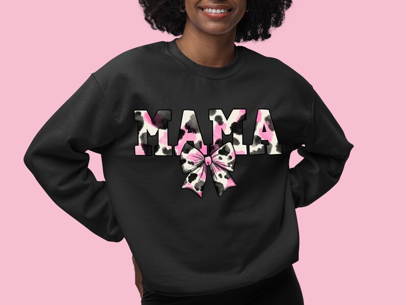 May include: Black sweatshirt with the word "MAMA" in pink and black cow print with a pink and black cow print bow.