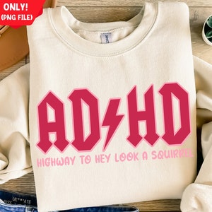 May include: A cream colored sweatshirt with a pink and red graphic that says "AD/HD HIGHWAY TO HEY LOOK A SQUIRREL".