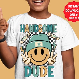 Puede incluir: Camiseta blanca con un diseño gráfico que presenta una cara sonriente con un gorro azul y un fondo a cuadros. El texto "HANDSOME DUDE" está impreso en la camiseta.