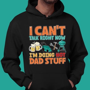 May include: Black hooded sweatshirt with a graphic print that says "I can't talk right now I'm doing hot dad stuff". The graphic includes a beer, lawnmower, wrench, hammer, and grill.