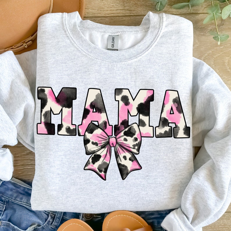 May include: A gray sweatshirt with the word "MAMA" in pink and black leopard print letters. A pink and black leopard print bow is centered below the word.