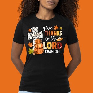May include: Black t-shirt with a white cross, pumpkins, and a pie. The text reads "give THANKS to the LORD PSALM 136:1".
