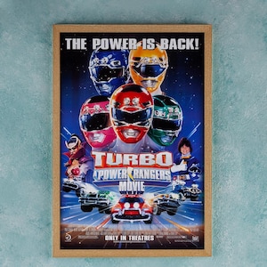 May include: A movie poster for the film "Turbo: A Power Rangers Movie". The poster features the five Power Rangers in their colourful suits, with the Red Ranger in the centre. The poster also features the text "The Power is Back!" and "Only in Cinemas".