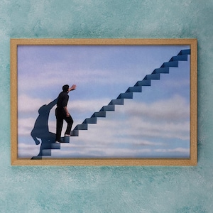 May include: Framed artwork showing a person climbing a staircase towards the sky. The person, dressed in black, casts a large shadow. The artwork is presented in a light brown wooden frame.