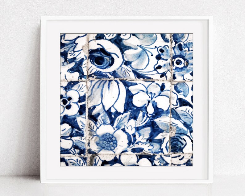 May include: A close-up of blue and white floral patterned tiles. The tiles are arranged in a grid pattern and have a distressed, vintage look.