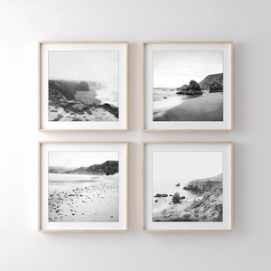Puede incluir: Un conjunto de cuatro cuadros cuadrados con marcos de madera clara, cada uno con una fotograf&iacute;a de paisaje en blanco y negro de una costa con acantilados rocosos, playas de arena y olas bajo un cielo brillante y nublado.