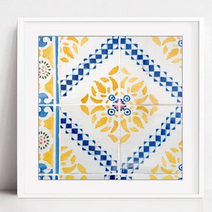 May include: A close-up of a colorful tile pattern with yellow, blue, and white geometric shapes. The tile pattern is framed in a white frame.