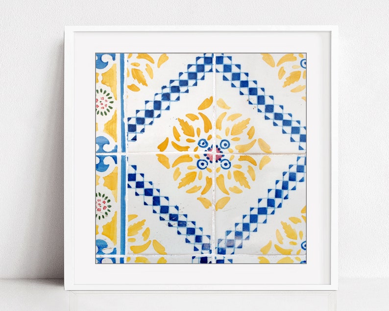 May include: A close-up of a colorful tile pattern with yellow, blue, and white geometric shapes. The tile pattern is framed in a white frame.