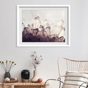 Pu&ograve; includere: Una stampa d'arte incorniciata che raffigura un gruppo di cristalli di quarzo traslucidi e appuntiti in tonalit&agrave; di bianco, grigio e viola intenso. L'opera &egrave; esposta in una cornice bianca pulita, che mette in risalto le sfaccettature geometriche.