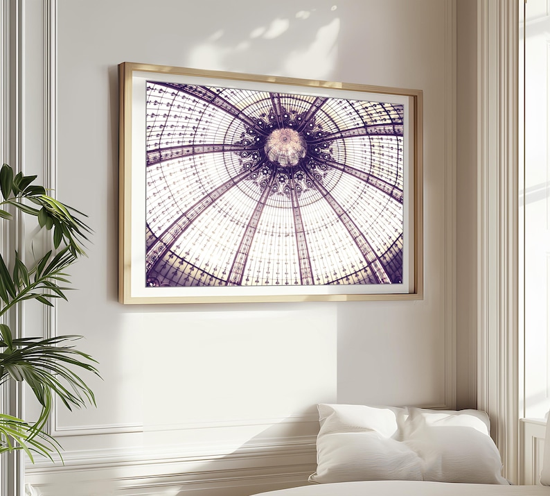 May include: A framed print featuring a detailed architectural rendering of a domed ceiling. The artwork showcases a symmetrical design with intricate patterns in shades of purple, white, and gold. The print is encased in a gold-colored frame, adding a touch of elegance.
