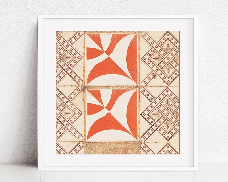 May include: A close-up of two orange and white patterned tiles with a geometric design. The tiles are framed in a white frame.