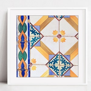 May include: A close-up of a colorful tile pattern with blue, green, yellow, orange, and brown geometric shapes. The tile pattern is framed in a white frame.