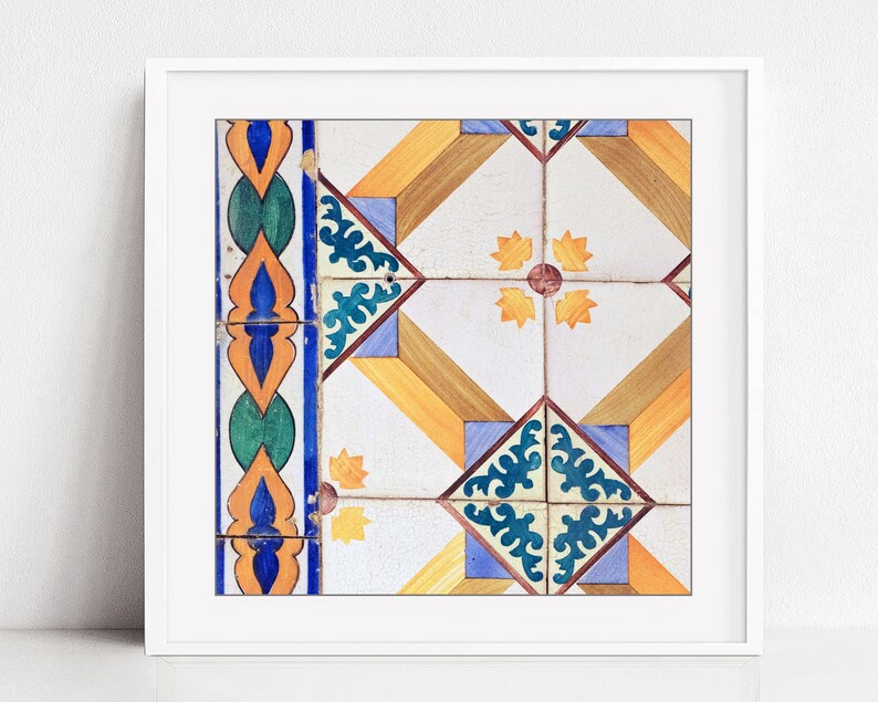 May include: A close-up of a colorful tile pattern with blue, green, yellow, orange, and brown geometric shapes. The tile pattern is framed in a white frame.