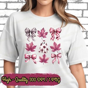 Puede incluir: Una camiseta blanca con un diseño rosa y blanco con lazos, hojas y un fantasma. El diseño está centrado en la camiseta y está rodeado de un fondo blanco.