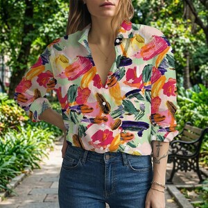 Pode incluir: Uma camisa abotoada com um vibrante padrão floral abstrato em tons de rosa, laranja, amarelo, verde e roxo. A camisa é combinada com jeans azuis. A camisa de manga comprida tem gola.