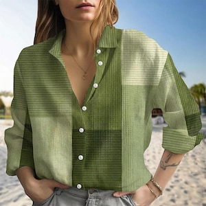 May include: Green button-down shirt with a patchwork design. The shirt features a mix of light and dark green squares and stripes. It has long sleeves and white buttons. The shirt is made of a soft, comfortable material.