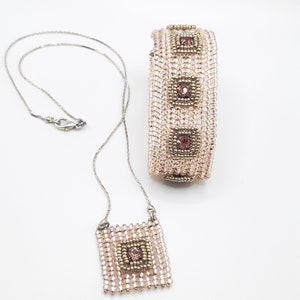 Pu&ograve; includere: Un delicato set di braccialetto e collana con perline rosa e argento con pietre preziose rosa di forma quadrata. Il set si chiama "Square Solitaire Bracelet & Penda" ed &egrave; di "Smadar's Treasure".
