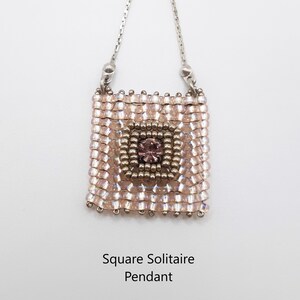 Pu&ograve; includere: Una collana con un ciondolo quadrato solitario con un designo di perline rosa e dorate e un piccolo cristallo rosa al centro. La collana &egrave; su una catena d'argento. "Square Solitaire Pendant &copy; Smadar's Treasure" &egrave; scritto sotto il ciondolo.