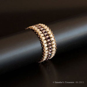 May include: A beaded bracelet with a geometric pattern in shades of brown, white, and gold. The bracelet is made with small, faceted beads and is designed in a chevron pattern.