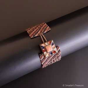 May include: A beaded bracelet with a square-shaped charm featuring a pink stone surrounded by blue, white, and red accents. The bracelet is made with small, colorful beads in a woven pattern.